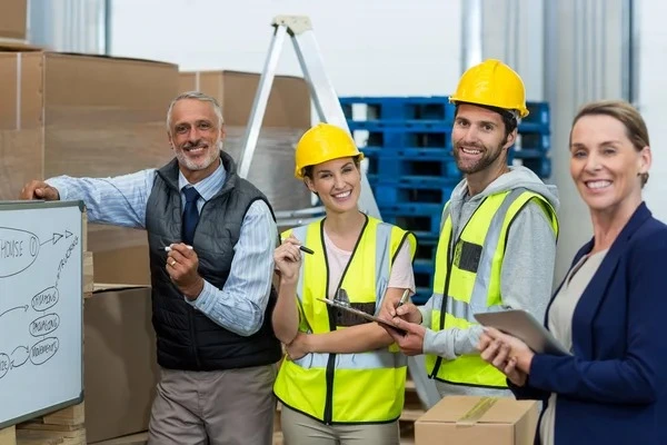 Warehouse manager and workers standing together